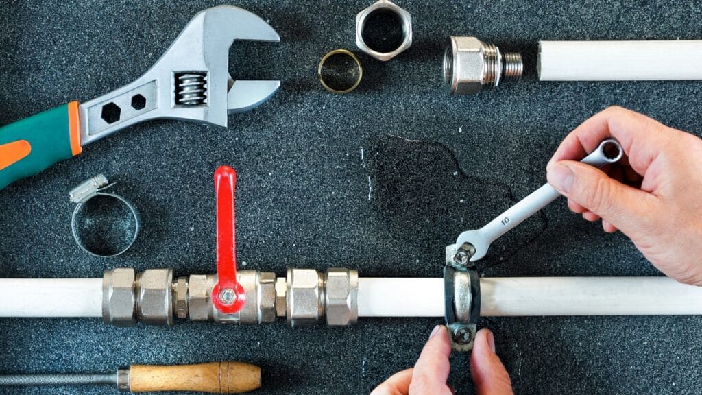 Plumber repairing a pipe valve with an adjustable wrench in Daytona Beach