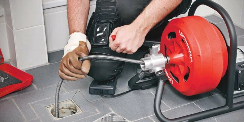 Plumber using a drain-cleaning machine in Daytona Beach