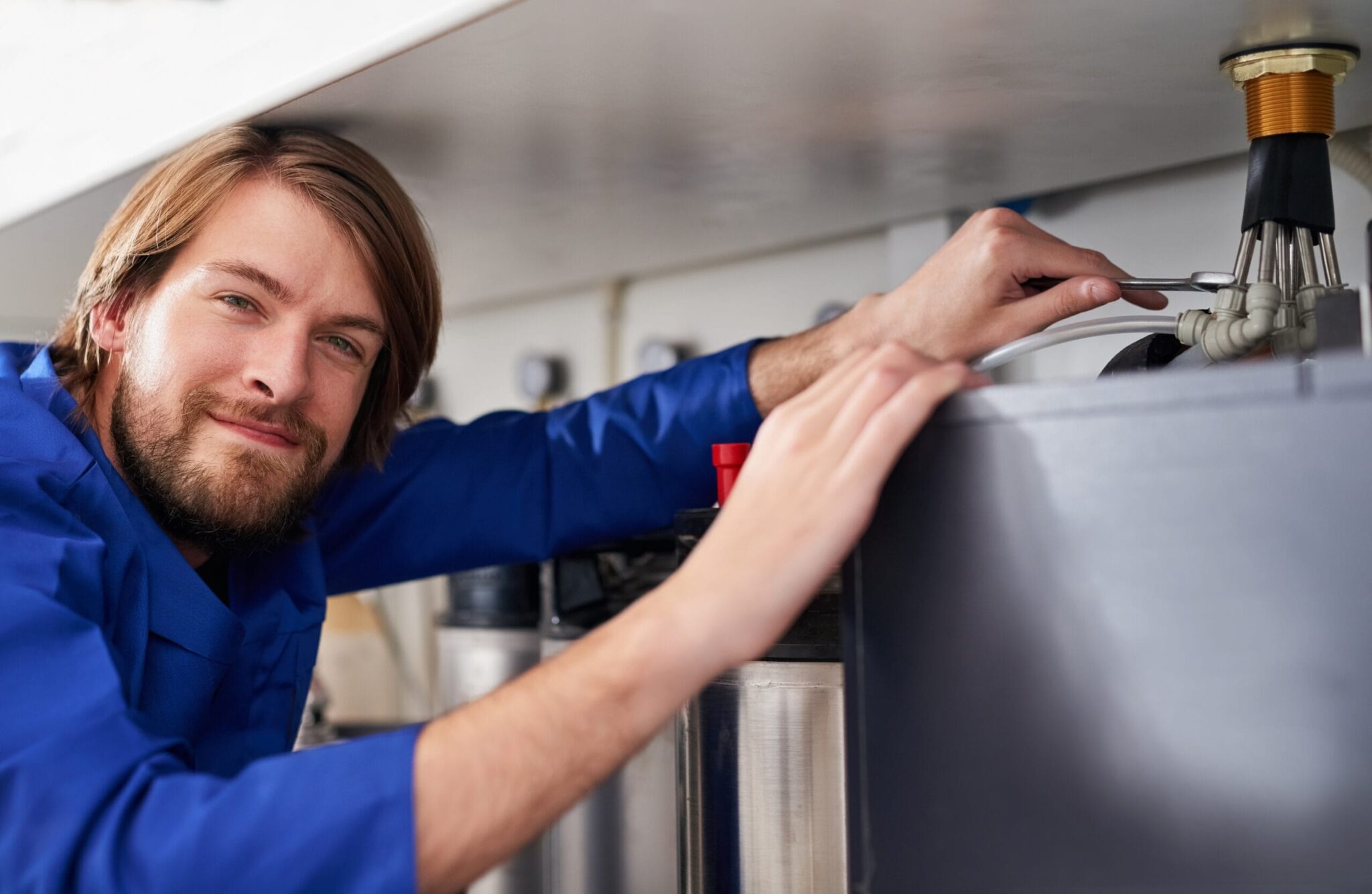 Technician servicing a residential water heater tank in Daytona Beach