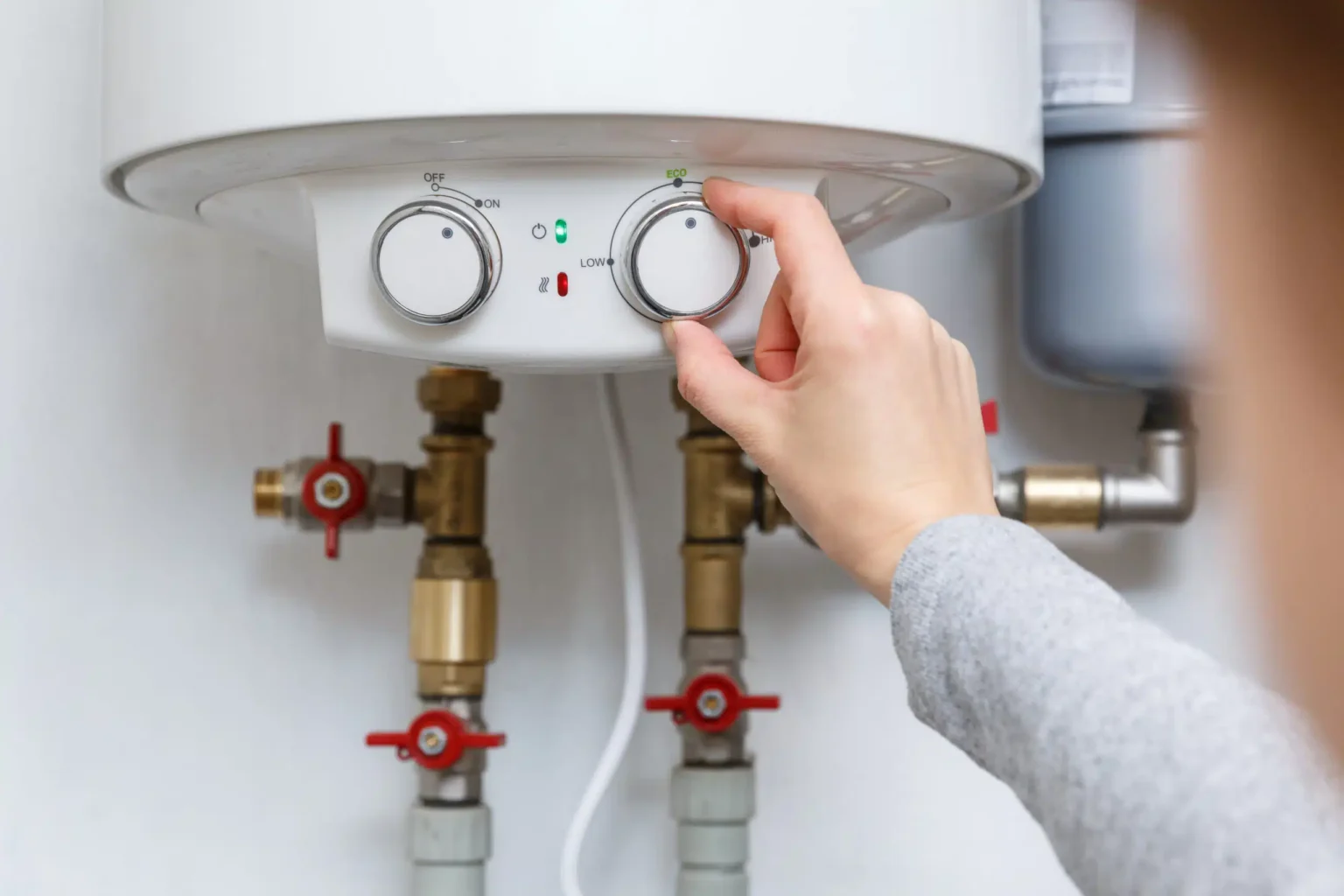 Homeowner adjusting the temperature controls on a water heater in Daytona Beach